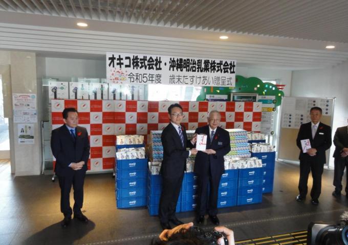 沖縄明治乳業㈱代表取締役副社長関場裕様からぜんざいとドリンクの贈呈