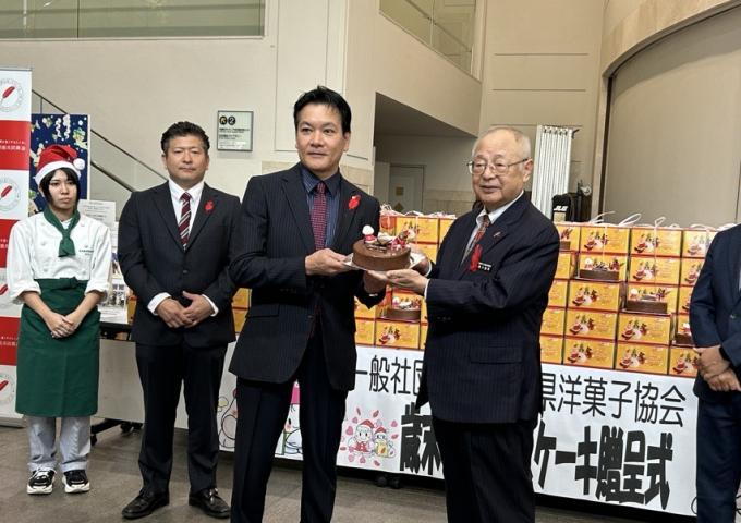 県洋菓子協会の諸見晃会長から県共同募金会の湧川昌秀会長へ